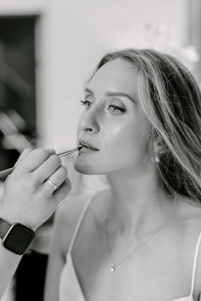 bride having her makeup done on her wedding day